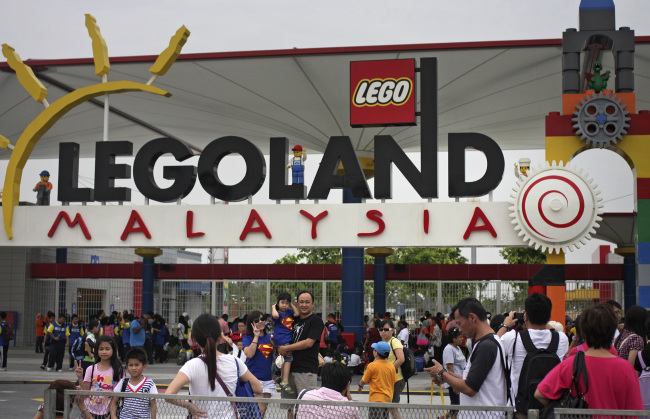 Visitors take photographs at the entrance to Legoland Malaysia, operated by Themed Attractions and Resorts Sdn., in Kota Iskandar, Johor, Malaysia, in 2012.   Bloomberg