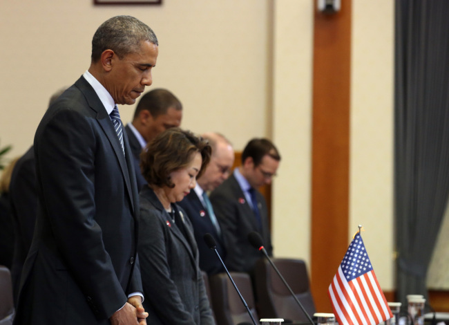 President Obama and his aides give silent prayer for the victims of the sunken ferry before starting summit talks with South Korea at Cheong Wa Dae on Friday. (Yonhap)