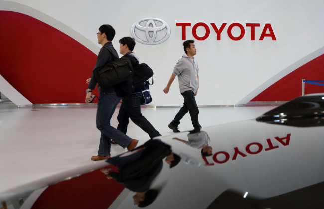 Visitors walk past the Toyota Motor Corp. logo displayed at the company’s showroom in Tokyo.   Bloomberg
