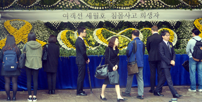 People pay their respects at a joint memorial altar for the ferry disaster victims in front of City Hall in Seoul on Monday.   Kim Myung-sub/The Korea Herald