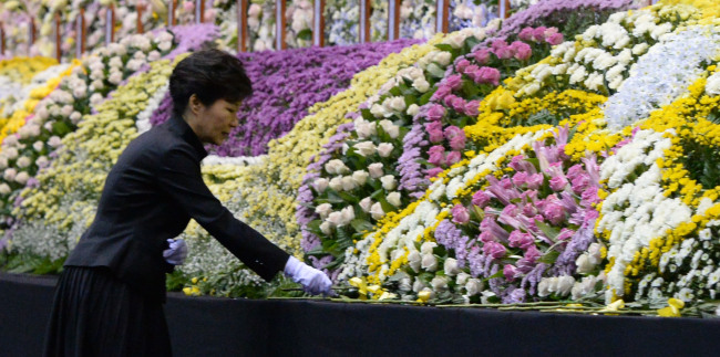 President Park Geun-hye lays down a flower at the mourning altar in Ansan, Gyeonggi Province, Tuesday.   Park Hyun-koo/The Korea Herald