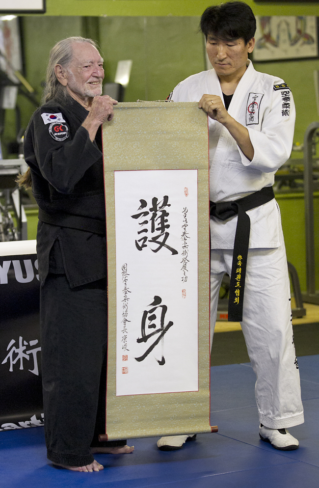 Willie Nelson, the country music icon who turns 81 this week, receives his fifth-degree black belt in the martial art of Gong Kwon Yu Sul in Austin, Texas, Monday.   AP-Yonhap