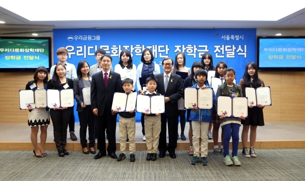 이순우 우리금융그룹 회장 겸 우리다문화장학재단 이사장(가운데 오른쪽)및 김상범 서울시 행정1부시장(가운데 왼쪽)이 ‘2014년 우리다문화장학재단 장학금 전달식’에서 다문화 장학생들과 함께 기념촬영을 하고 있다.