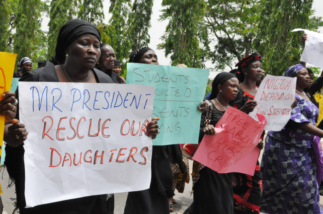 Unidentified mothers call for the president to help, during a demonstration with others who have daughters among the kidnapped school girls of government secondary school Chibok in Abuja on Tuesday.   AP-Yonhap
