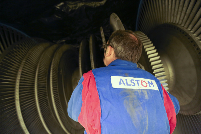 An Alstom employee inspects a turbine at Alstom SA's power plant turbine refurbishment facility in Rugby, U.K, on Tuesday, April 29, 2014. The battle for Alstom intensified after Siemens AG stepped up plans for a bid to counter General Electric Co. (GE) in what would be the biggest tug of war for a French industrial company ever. Photographer: Chris Ratcliffe/Bloomberg
An employee inspects a turbine at Alstom SA’s power plant turbine refurbishment facility in Rugby, England.   Bloomberg