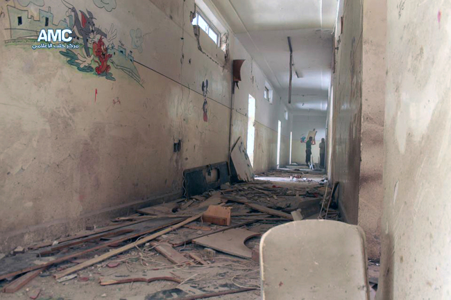 Two Syrian men stand inside a school that was hit by a Syrian government air strike in Aleppo, Syria, Wednesday.   AP-Yonhap