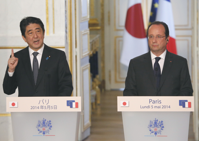 French President Francois Hollande (right) listens as Japanese Prime Minister Shinzo Abe speaks at a press conference after their meeting at the Elysee Palace in Paris on Monday.   AP-Yonhap