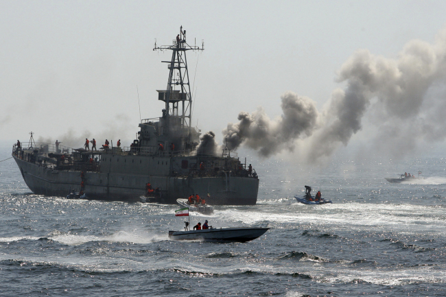 Iranian Revolutionary Guard’s troops attack and take over a warship, being used as a target, during a maneuver in the Persian Gulf on April 22, 2010.   AP-Yonhap