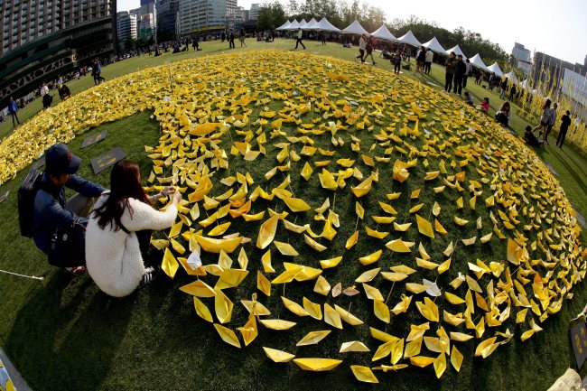 People put out yellow paper boats symbolizing their hopes for the safe return of Sewol’s passengers outside City Hall in Seoul on Wednesday.   EPA-Yonhap