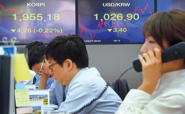 Dealers at Korea Exchange Bank headquarters in downtown Seoul are busy in action as the exchange rate between the Korean won and the U.S. dollar tumbled on Wednesday. Yonhap