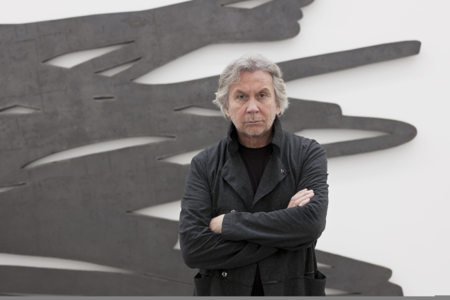 Bernar Venet poses for a photo in front a steel sculpture. Bernar Venet Studio