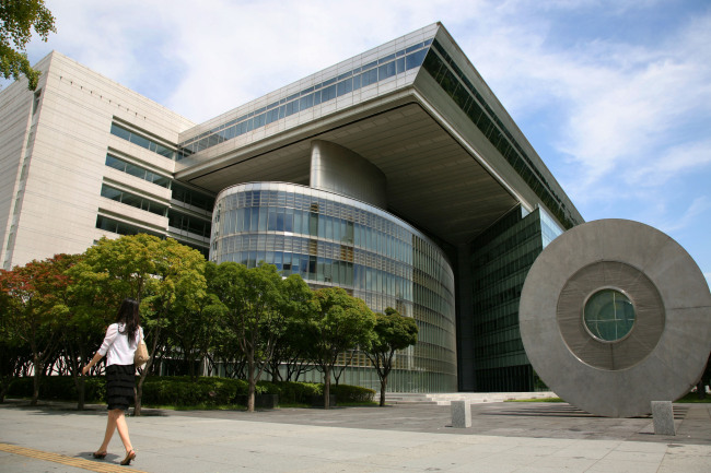 A woman walks past the Korea Development Bank headquarters in Seoul.   Bloomberg