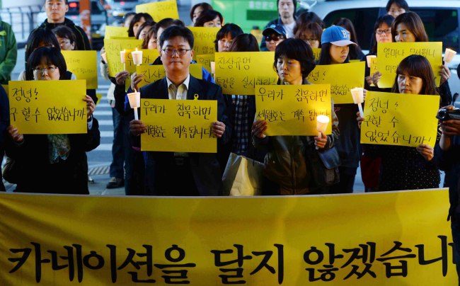 Members of a parents’ organization hold candles in place of carnations in remembrance of the Sewol tragedy victims during a Parents’ Day rally in Seoul on Thursday.   Park Hyun-koo/The Korea Herald