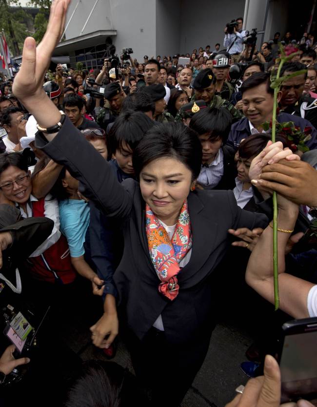 Ousted Thai Prime Minister Yingluck Shinawatra (center) waves to her supporters in a suburb of Bangkok on Wednesday.   AFP-Yonhap