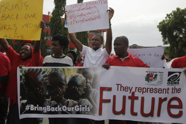 People attend a demonstration calling on the government to rescue the kidnapped schoolgirls of a government secondary school Chibok, outside the defense headquarters in Abuja, Nigeria, Tuesday.   AP-Yonhap