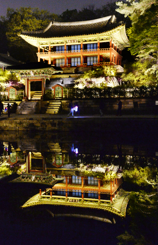 Gyujanggak, the royal library of the Joseon period, is reflected on Buyongji Pond in Changdeokgung Palace during the full moon in Seoul on April 16.   Park Hyun-koo/The Korea Herald