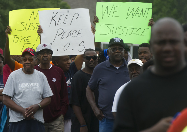 Protesters carry signs while marching to the Hearne, Texas police department Thursday, following the Tuesday shooting of 93-year-old woman.   AP-Yonhap