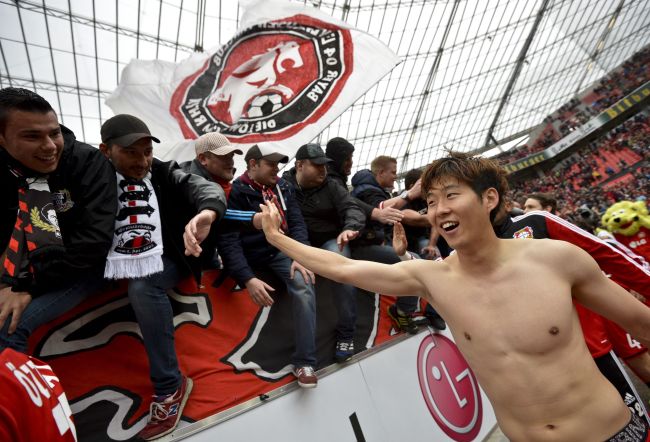 Leverkusen’s Son Heung-min celebrates with fans after the team’s match on Saturday.   AFP-Yonhap
