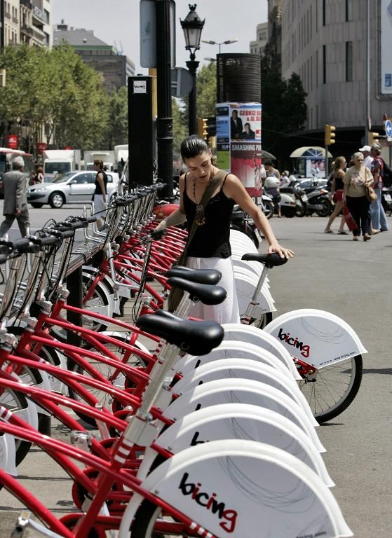 A girl takes a “Bicing” bike ― part of a shared bicycle scheme ― for a ride in Barcelona.   AFP