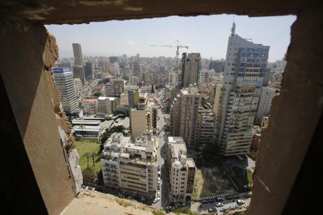 An area of West Beirut is seen through a window of the abandoned Holiday Inn hotel in Beirut.   AFP
