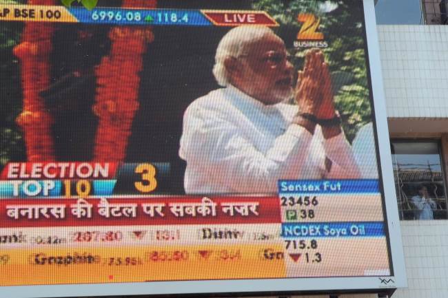 An image of Bharatiya Janata Party prime ministerial candidate Narendra Modi is pictured with rolling share price information on a digital broadcast on the facade of the Bombay Stock Exchange headquarters in Mumbai, India, Monday.   AFP-Yonhap