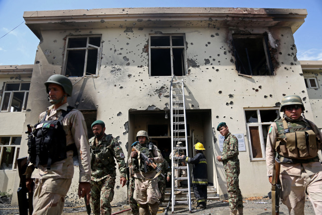 Afghan security personal surround the area after Taliban fighters stormed a government building in Jalalabad, east of Kabul, Monday.   AP-Yonhap
