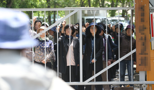 Members of a religious group founded by Yoo Byung-eon’s family block prosecutors from entering the facility where Yoo is thought to be residing in Anseong, Gyeonggi Province, Tuesday.   Yonhap