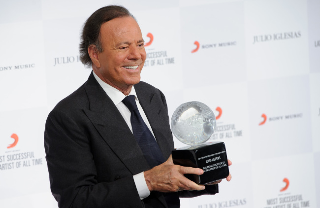 Spanish singer Julio Iglesias poses for photographers at a press conference with his award after being named the “Most Successful Latin Artist of All Time” at a central London venue on Monday.    AP-Yonhap