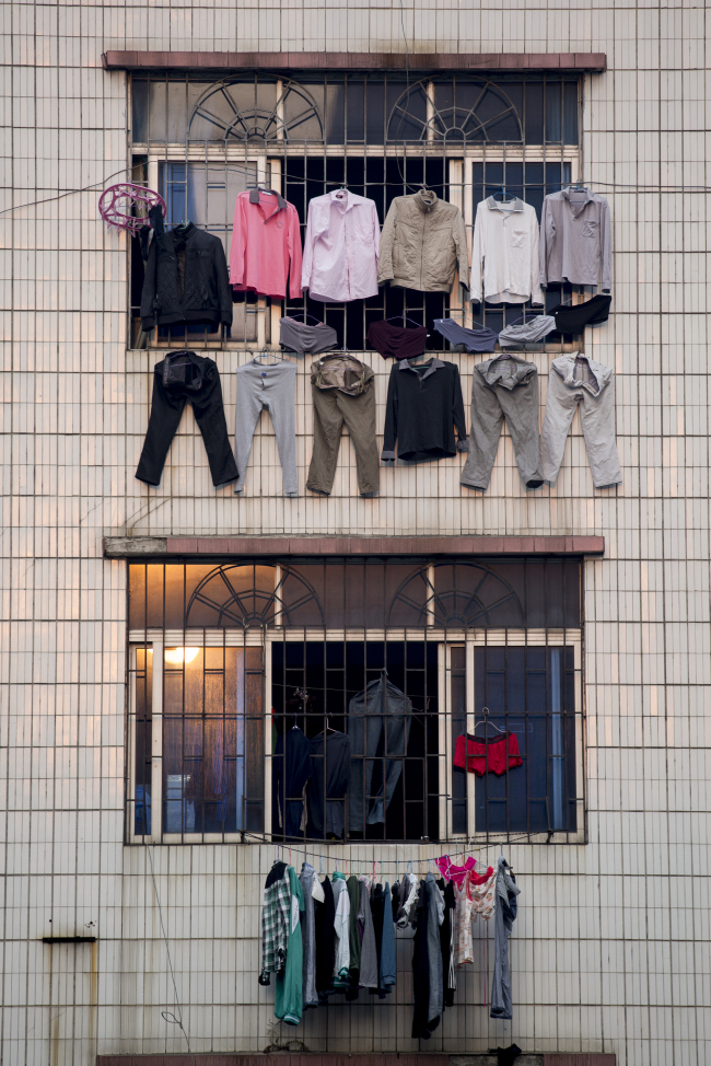 Laundry hangs to dry outside a residential building in the Zhujiang New Town district of Guangzhou, Guangdong province, China.    Bloomberg