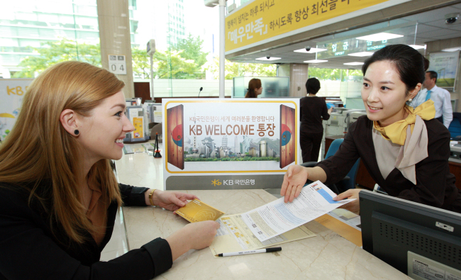 A foreign customer consults with an employee at a KB Kookmin Bank branch in Seoul.   KB Kookmin Bank
