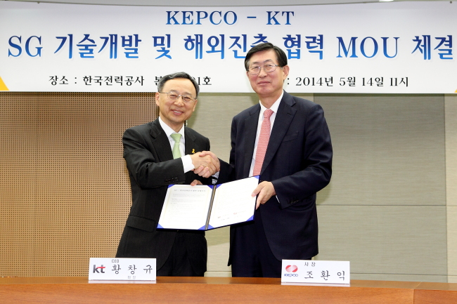 KEPCO CEO Cho Hwan-ik (right) shakes hands with KT chairman Hwang Chang-gyu after signing an MOU for overseas smart grid project development and cooperation.   KEPCO