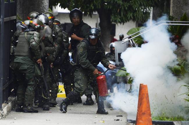 <YONHAP PHOTO-0264> TOPSHOTS..National Guard personnel in riot gear struggle with anti-government demonstrators during a protest in Caracas on May 14, 2014. About 80 demonstrators were arrested during a protest as they request the immediate release of youth detained in recent days. AFP PHOTO/JUAN BARRETO../2014-05-15 07:05:52/ <저작권자 ⓒ 1980-2014 ㈜연합뉴스. 무단 전재 재배포 금지.>
National Guard personnel in riot gear struggle with antigovernment demonstrators during a protest in Caracas on Wednesday.   AFP-Yonhap