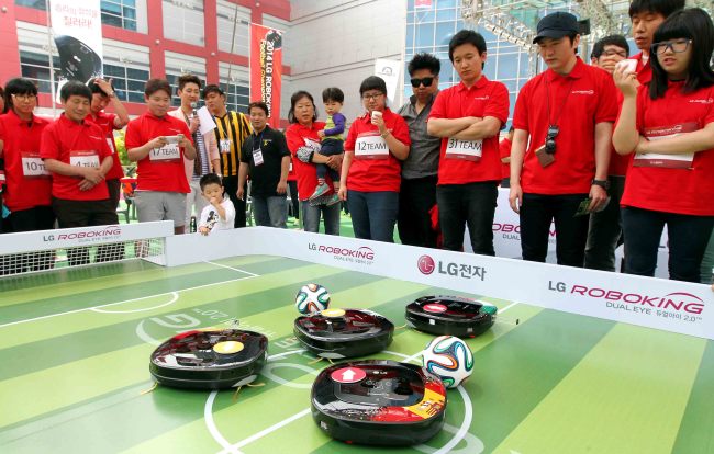 LG전자는 지난 18일 서울 용산구 아이파크몰에서 다음달 브라질월드컵에 참가하는 대한민국 축구 대표팀의 승리를 기원하는 ‘LG 로보킹 풋볼 챔피언십’ 행사를 개최했다. 행사에 참가한 시민들이 스마트폰으로 로봇청소기 ‘로보킹’을 조작해 축구를 하며 즐거워하고 있다. ［사진제공=LG전자］