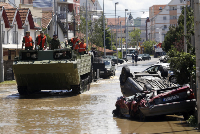 A military amphibious vehicle drives through a street where flood waters are retreating in Obrenovac, southwest of Belgrade, Monday.   AP-Yonhap