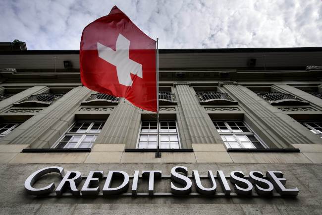 A Swiss flag flies over a Credit Suisse sign in Bern.   AFP-Yonhap