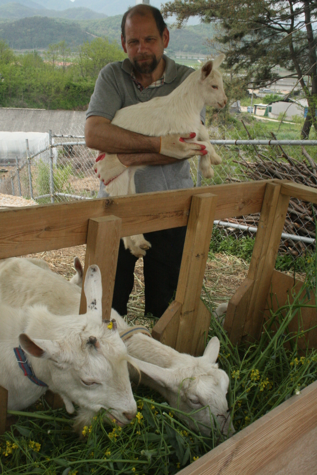 Doug Huffer poses with a kid on his goat farm near Gyeongju, North Gyeongsang Province.   Paul Kerry/The Korea Herald