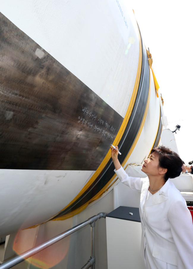 President Park Geun-hye writes a message on a Korean-made nuclear reactor to be installed at a power plant in Barakah, United Arab Emirates, Tuesday.   Yonhap