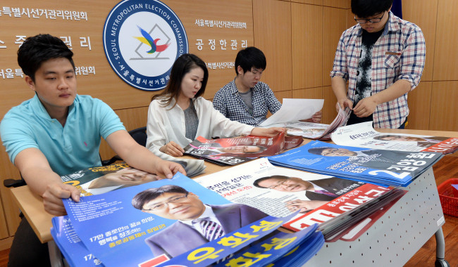 제 6회 6.4 전국동시지방선거 선거벽보 제출 마감일인 21일 오전 서울 종로구 선거관리위원회에서 관계자들이 제출된 선거벽보를 심사하고 있다. 17일 부터 시작된 선거벽보 제출은 21일 18시까지 마감이다./안훈 기자 rosedale@ 2014.05.21
Officials prepare the campaign posters for the June 4 local elections at the National Election Commission in Seoul on Wednesday.
Ahn Hoon/The Korea Herald