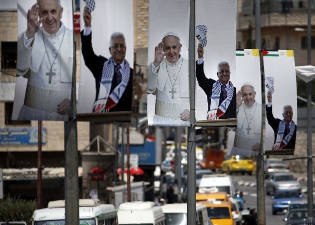 Banners bearing portraits of Pope Francis and Palestinian Authority President Mahmud Abbas are displayed on the main street of the West Bank town of Bethlehem on Tuesday.   AFP-Yonhap