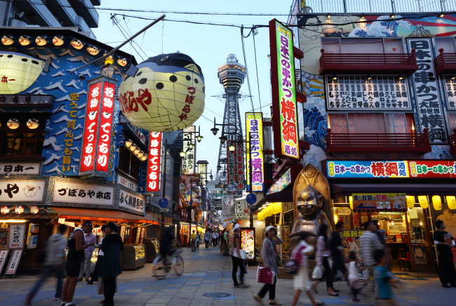 People walk past restaurants in the Shinsekai shopping district of Osaka.   Bloomberg