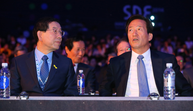 Seoul mayoral candidates Park Won-soon (left) and Chung Mong-joon speak at a forum in Seoul on Wednesday.   Yonhap