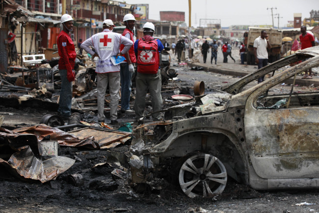Red Cross personnel search for remains at the site of car bombing in Jos, Nigeria, Wednesday.   AP-Yonhap