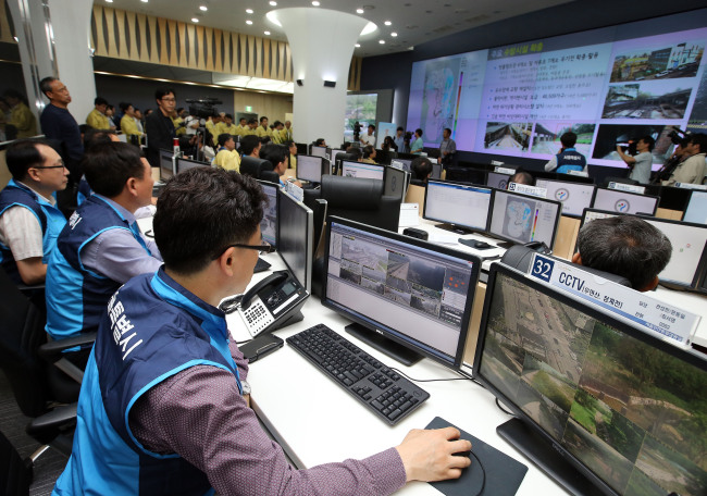Employees work at the disaster and safety countermeasures headquarters on May 15. The unit, established to help provide countermeasures for typhoons and floods ahead of the monsoon season, is part of the combined safety situation room at Seoul City Hall.   Yonhap