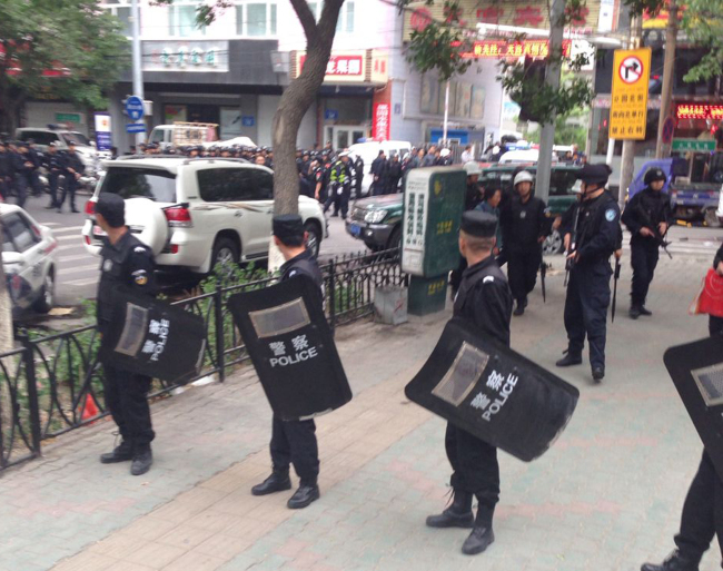 Police officers stand guard near a blast site which has been cordoned off in downtown Urumqi, capital of northwest China’s Xinjiang Uighur Autonomous Region, Thursday.   AP-Yonhap