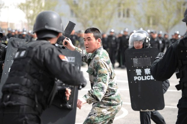 Armed policemen surround a knife-wielding 'attacker' during a counter-terrorism drill in Xinjiang's capital Urumqi, April 26, 2014.