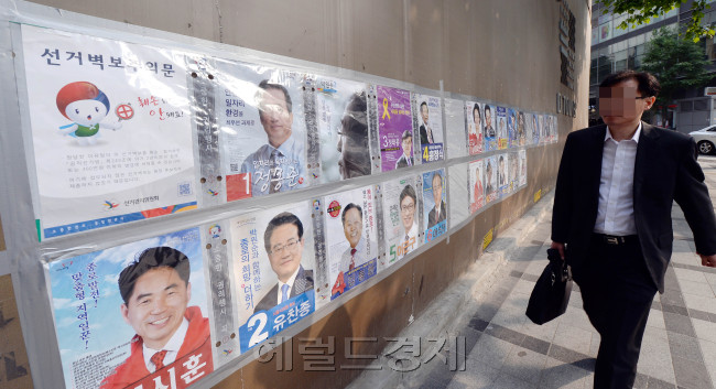 6.4 지방선거 공식 선거운동이 시작된 가운데 23일 오전 서울 종로구 도로가에 붙혀진 선거벽보를 시민들이 지나가며 살피고 있다./안훈 기자 rosedale@ 2014.05.23
6.4 지방선거 공식 선거운동이 시작된 가운데 23일 오전 서울 종로구 도로가에 붙혀진 선거벽보를 시민들이 지나가며 살피고 있다./안훈 기자 rosedale@ 2014.05.23
길다~길어, 선거벽보