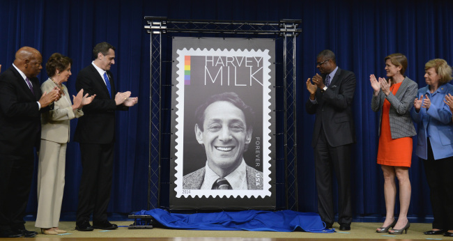 The Harvey Milk Forever Stamp is unveiled by his nephew Stuart Milk (third from left) and Deputy Postmaster General Ronald Stroman (third from right) in a dedication ceremony in the South Court Auditorium at the Eisenhower Executive Office Building in Washington on Thursday.   UPI-Yonhap