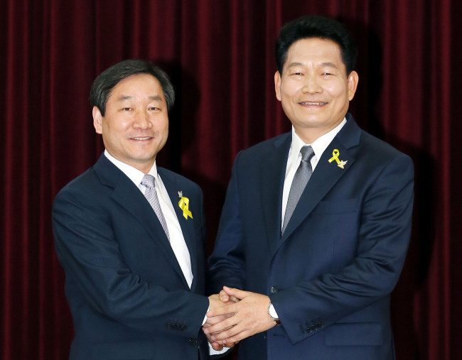 Incheon Mayor Song Young-gil (right) shakes hands with Saenuri Party candidate Yoo Jeong-bok during an event to pledge fair campaigns earlier this month.   Yonhap