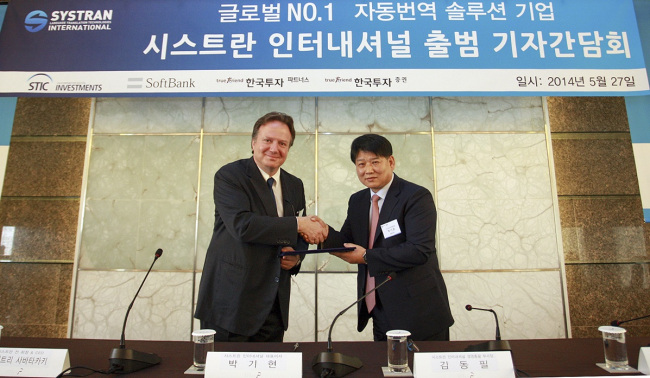 Dimitris Sabatakakis (left), former SYSTRAN chairman, and Park Ki-hyun, CEO of SYSTRAN International, shake hands ahead of a press conference to announce CSLi’s acquisition of SYSTRAN in Seoul on Tuesday.   SYSTRAN International