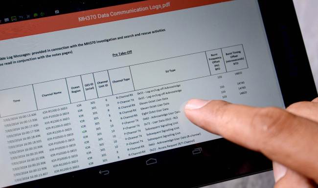 A journalist looks at the data communication logs from British satellite operator Inmarsat and released by Malaysia’s Department of Civil Aviation in Kuala Lumpur in relation to the missing Malaysia Airlines Flight MH370 on Tuesday.   AFP-Yonhap